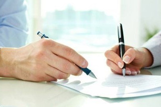 Ilustrativna slika ruku dvije osobe koje potpisuju dokument